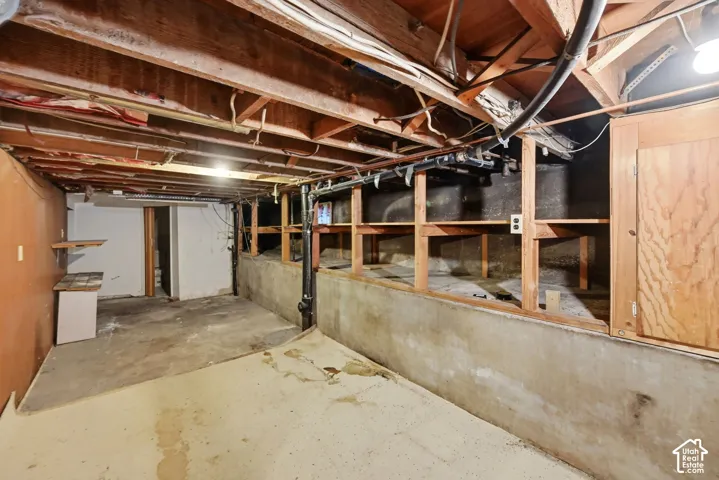 Concrete flooring, exposed ceiling joists, and built-in wood shelving