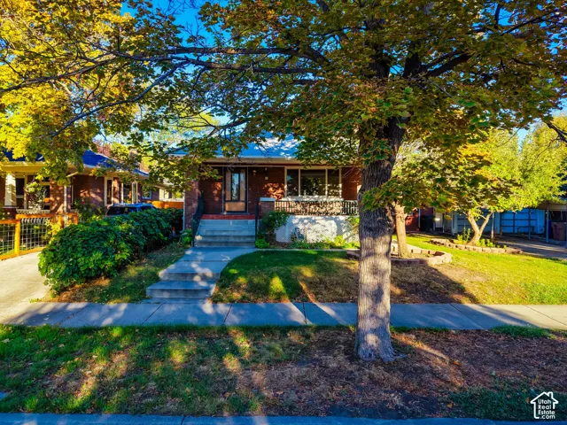 Brick exterior with a covered porch featuring metal railings