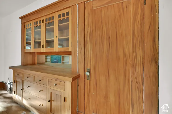 Built-in wood cabinetry with glass-front upper cabinets and drawer storage
