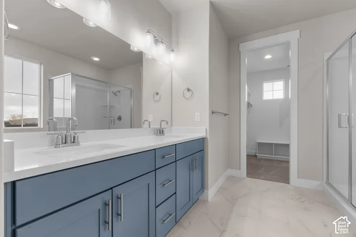 Dual vanity with blue cabinetry, white countertop, and chrome fixtures