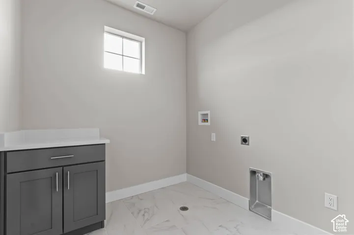 Utility room with a window, contemporary dark gray cabinetry, white countertop, and tile flooring