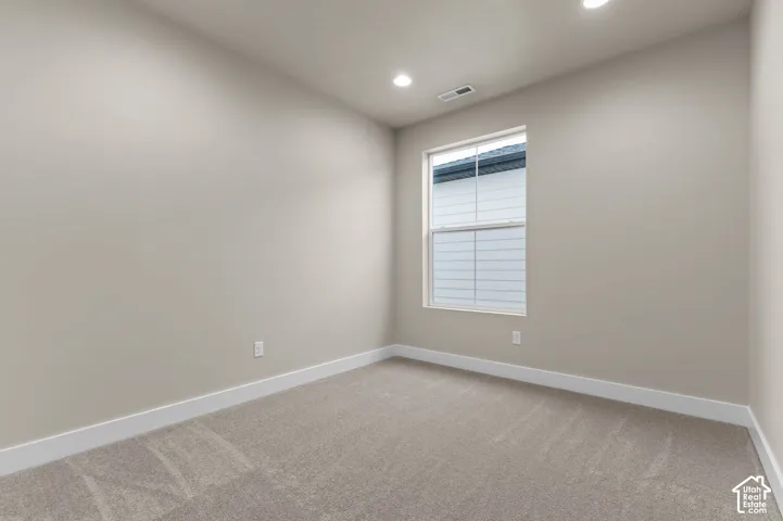 Carpeted flooring, recessed lighting, double-hung window, and neutral wall paint