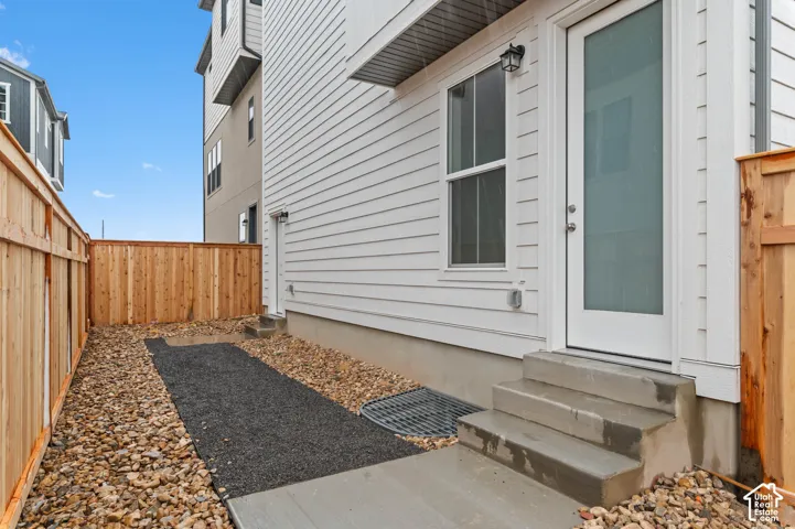 White horizontal siding exterior with a wood fence and concrete steps
