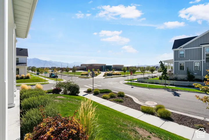 Mountain backdrop framing the neighborhood, with a streetscape featuring sidewalks, landscaped common areas, and contemporary residential architecture