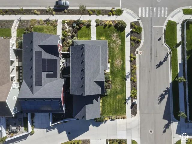 Asphalt shingle roofs, solar panels, concrete sidewalks, paved streets, and landscaped green spaces
