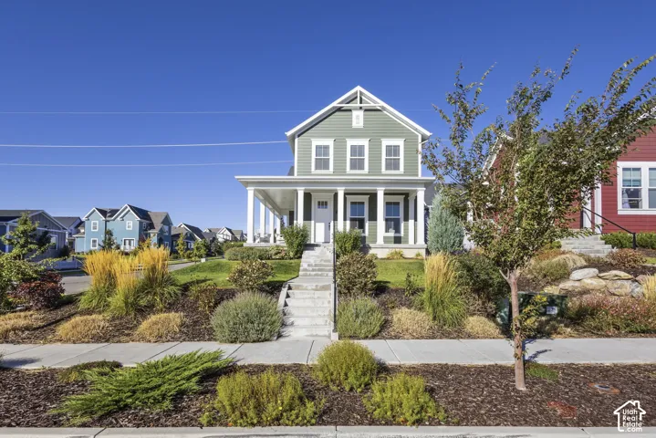 Green clapboard siding exterior with white trim and a covered front porch