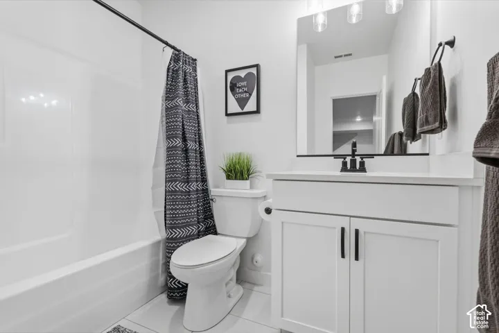 White vanity with a solid surface countertop, undermount sink, and matte black faucet