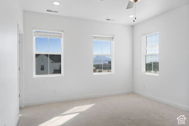 Room featuring three windows, recessed lighting, and a ceiling fan