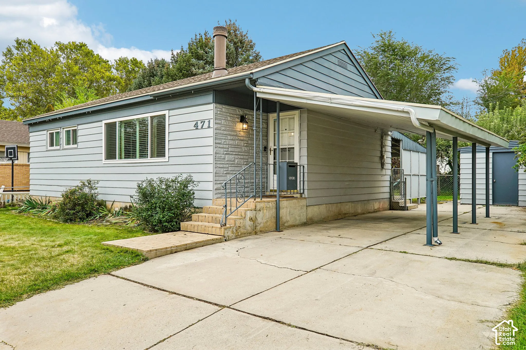 Charming mid-century residence featuring clean-lined white siding, a pitched roof with chimney, and expansive front-facing windows