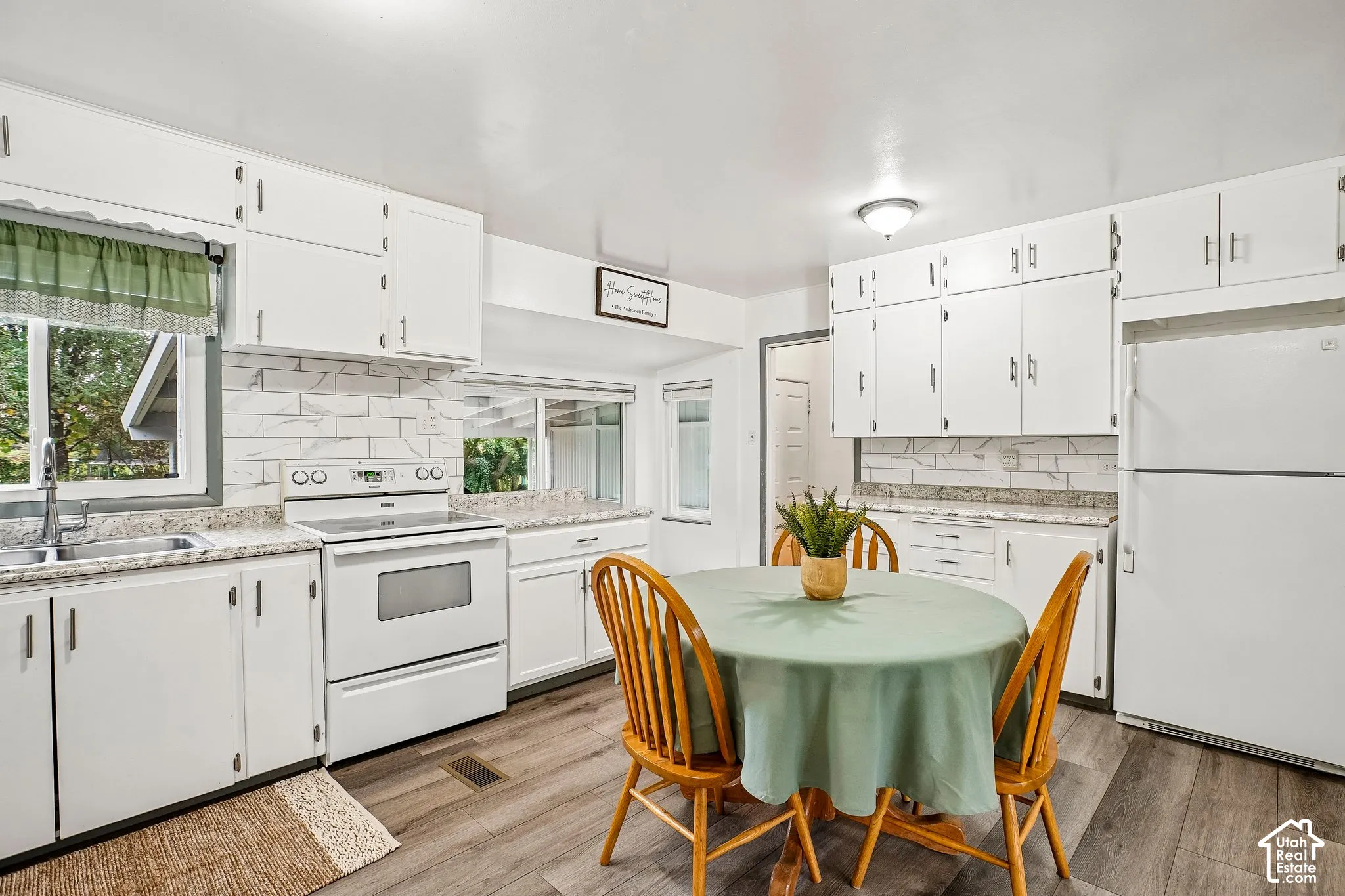 Bright, updated kitchen featuring white cabinetry, subway tile backsplash, and stainless steel appliances including a gas range and refrigerator