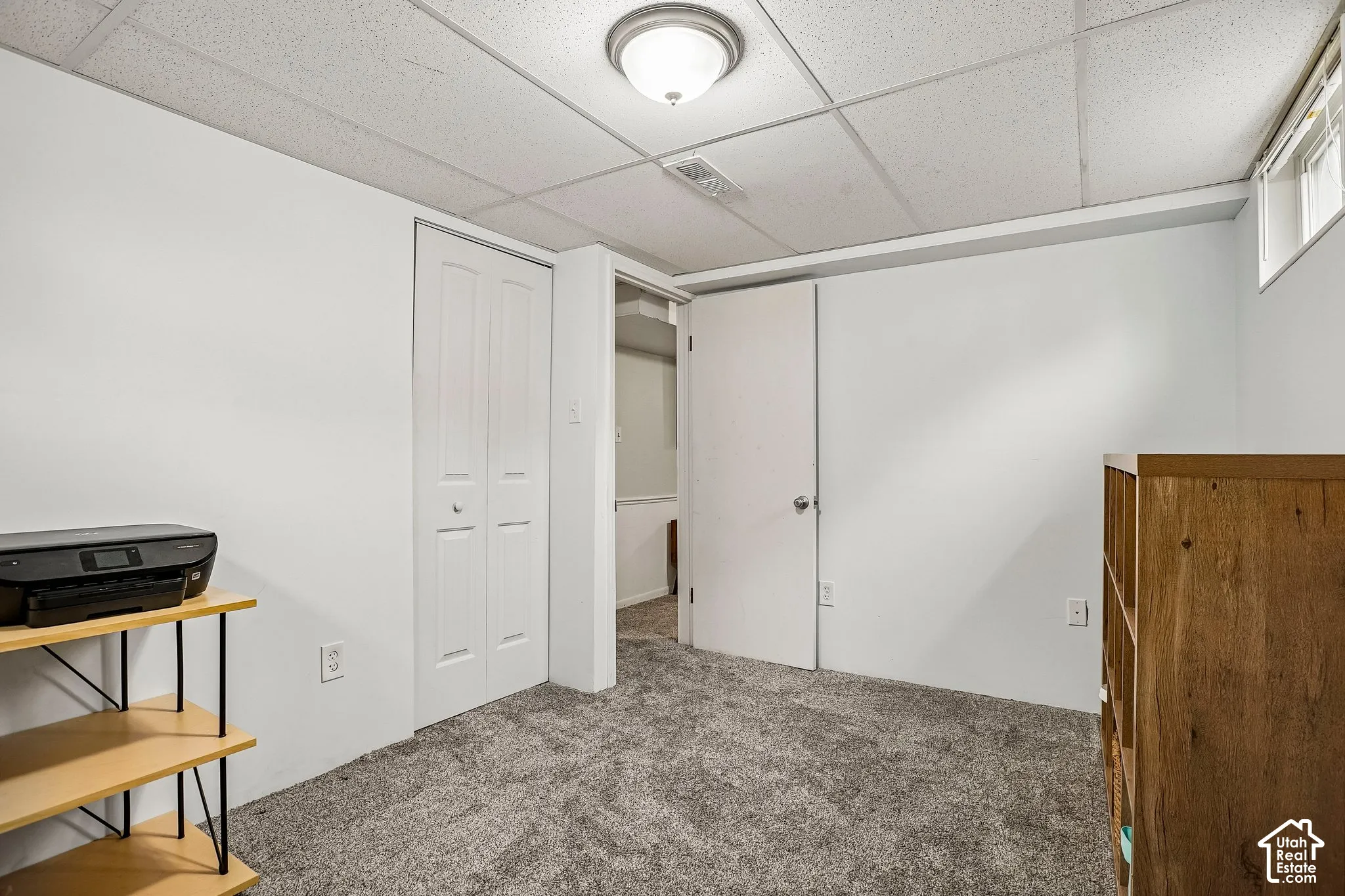 White walls, gray carpet, and a drop ceiling