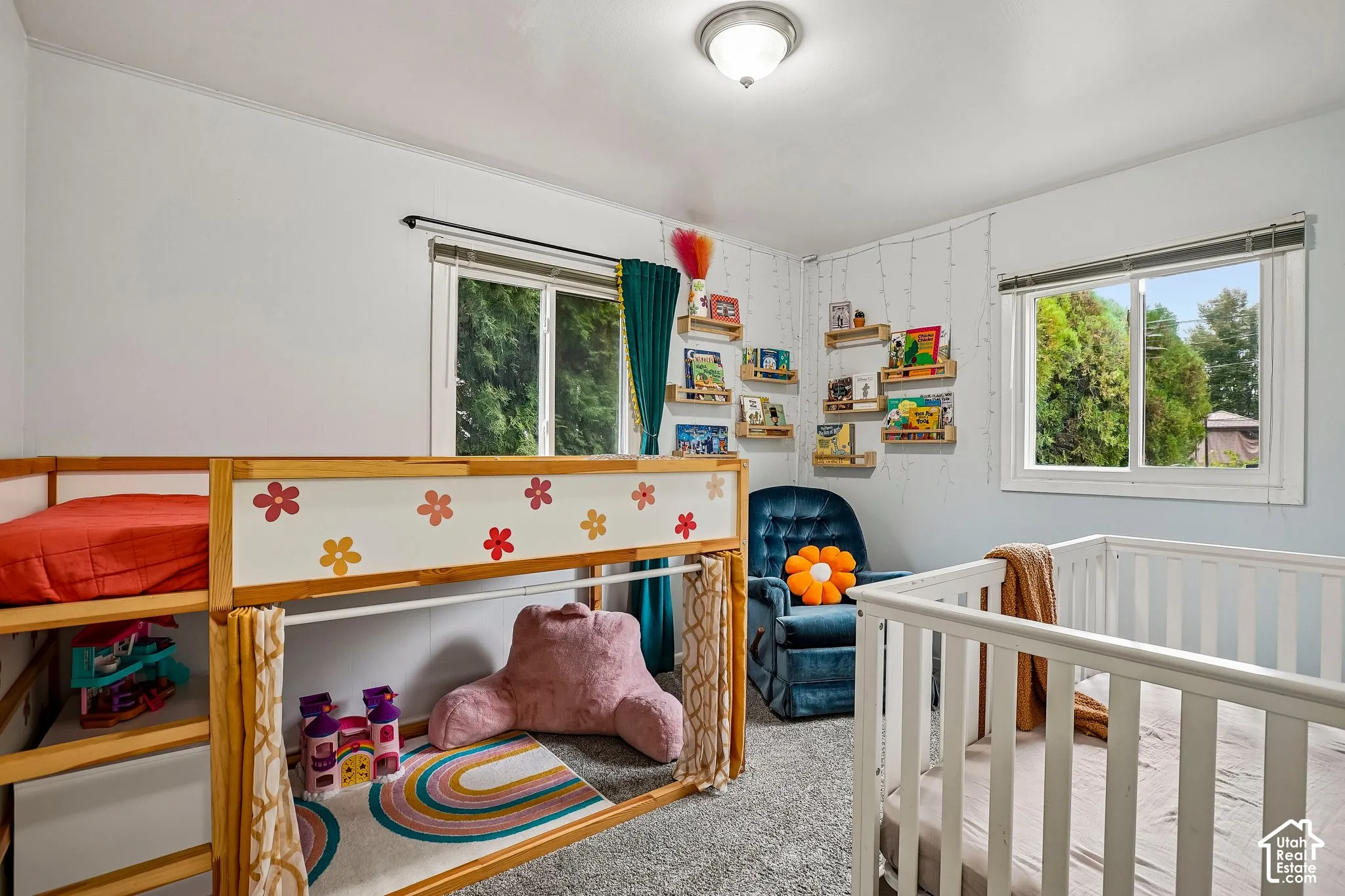 Recessed ceiling light fixture, wall-mounted book shelving, and two large windows