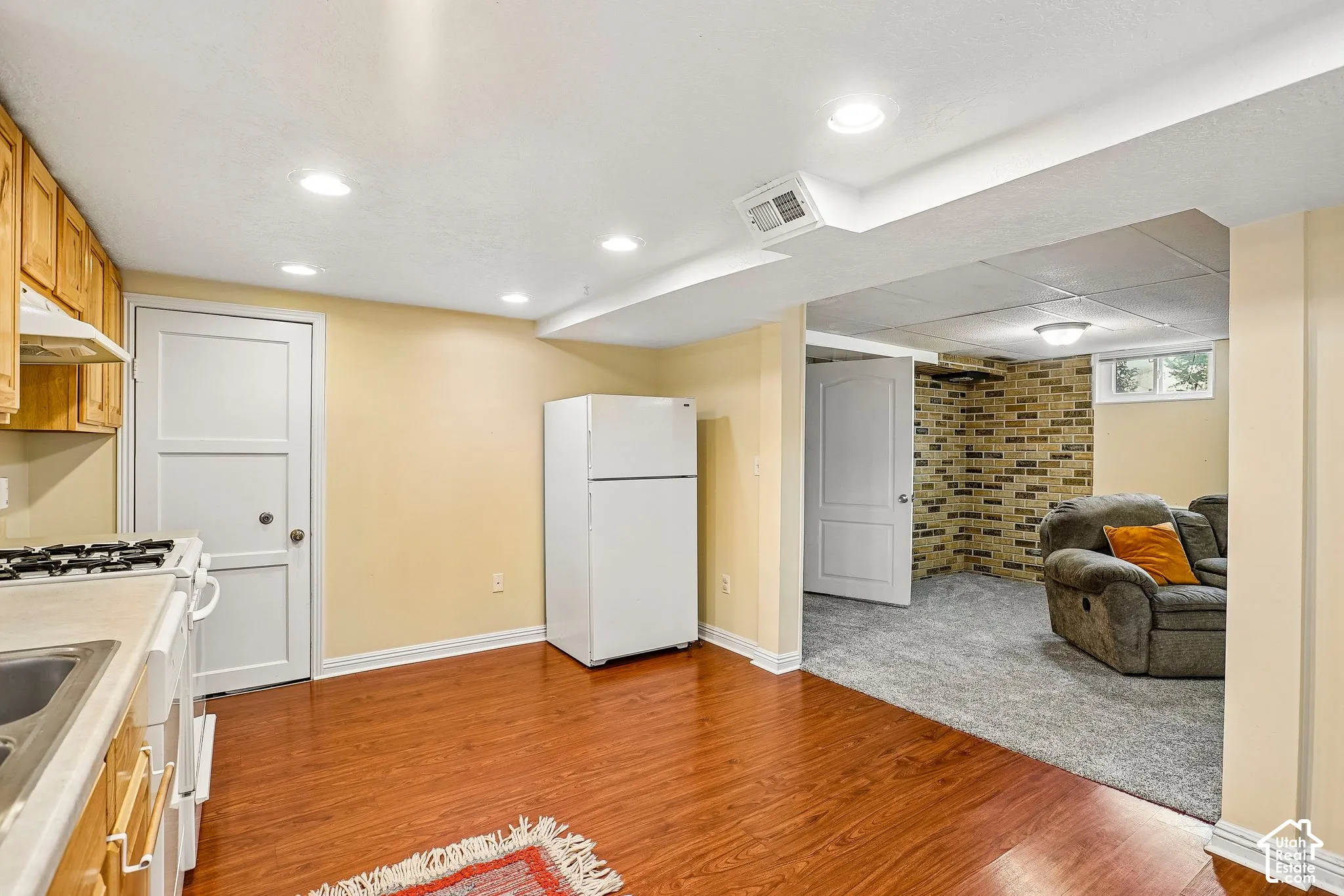 Kitchenette with wood-finish flooring, recessed lighting, and wooden cabinetry
