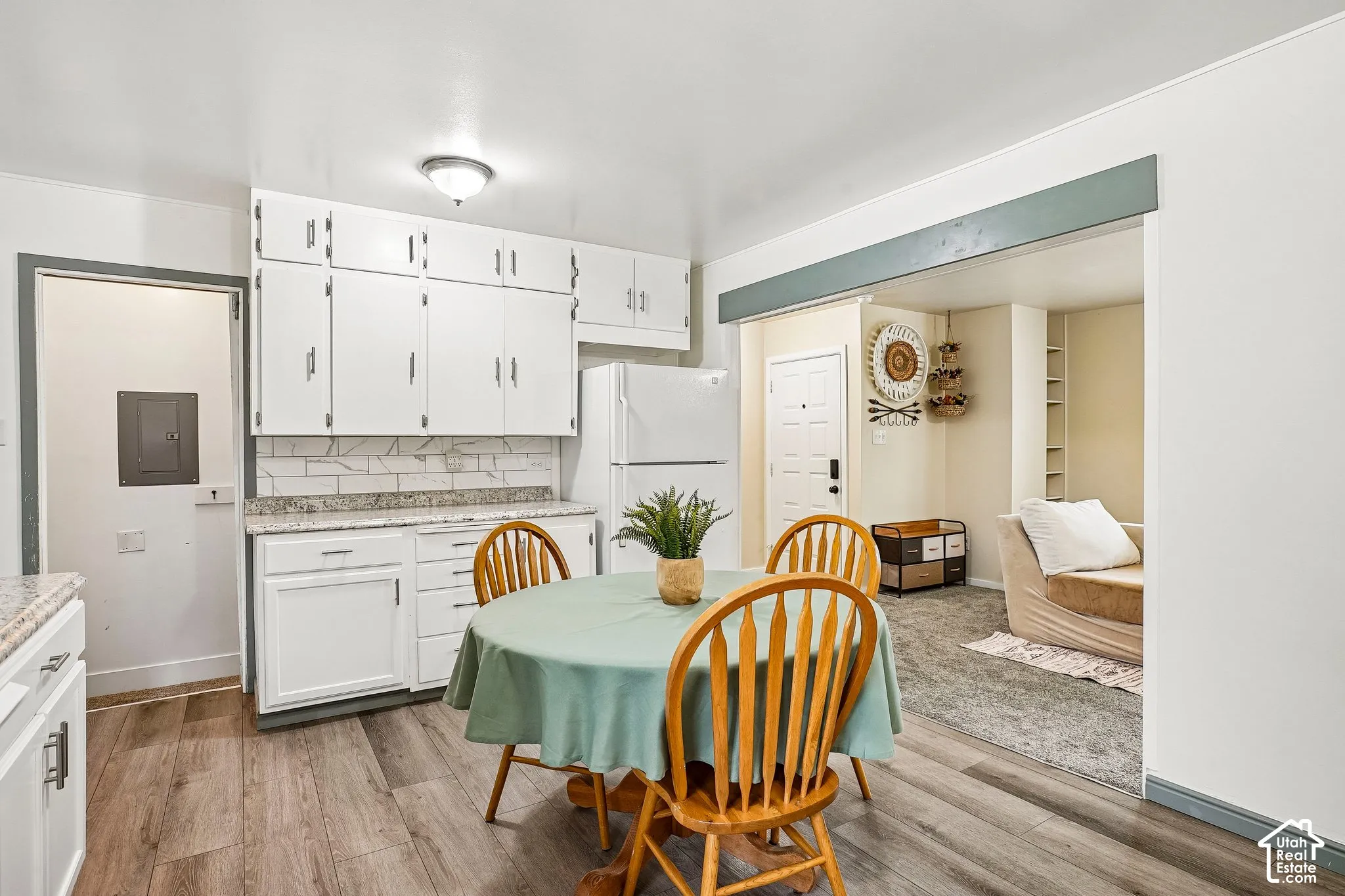 Kitchen featuring white cabinetry, granite-finish countertops, subway tile backsplash, wood-finish flooring, and a built-in refrigerator