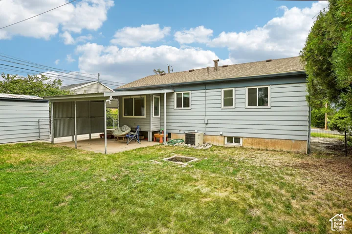 Rear exterior with horizontal siding, multiple windows, an attached covered patio, and a separate storage shed