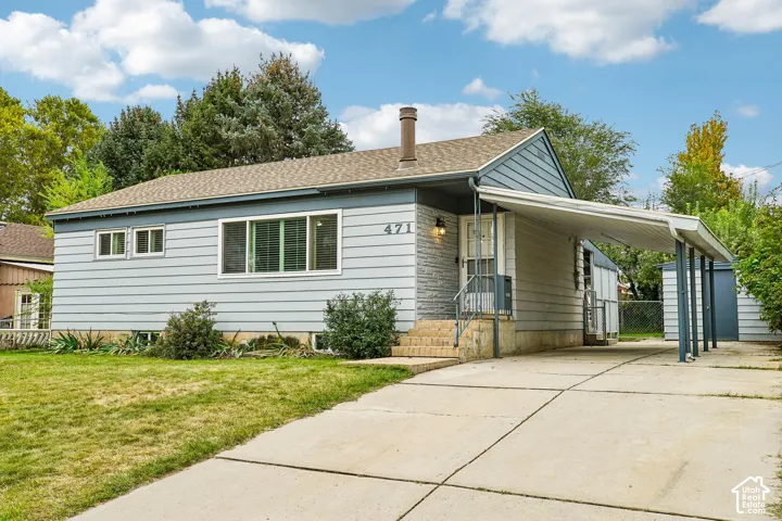 Light blue siding exterior with a carport and concrete driveway
