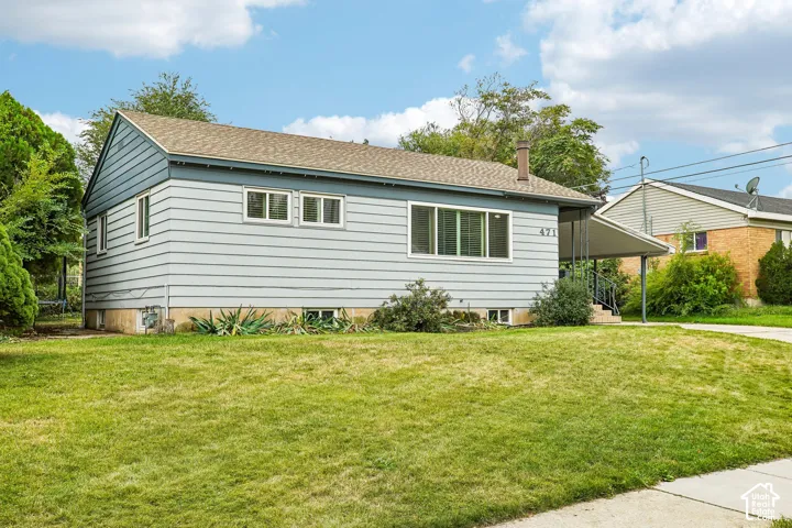 Single-story residence featuring light blue siding, a covered entry, and a front lawn with established landscaping