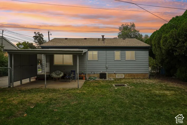 Rear exterior with horizontal siding, shingle roof, and a covered patio area