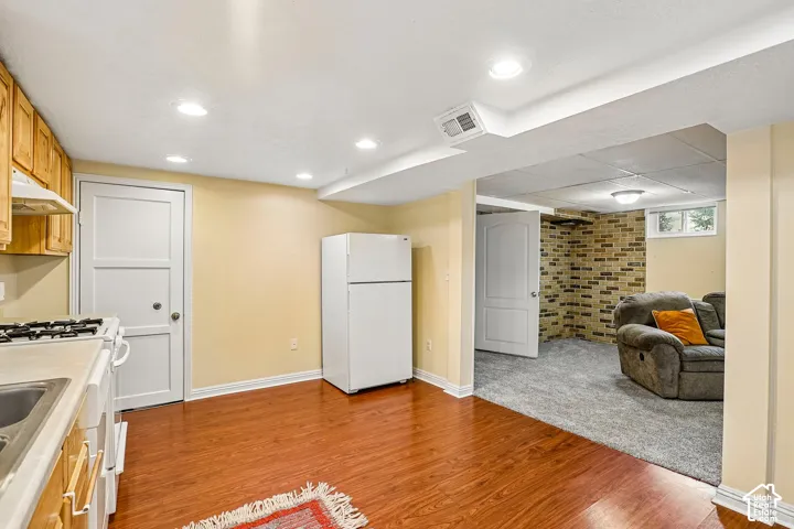 Kitchenette with wood-finish flooring, recessed lighting, and wooden cabinetry