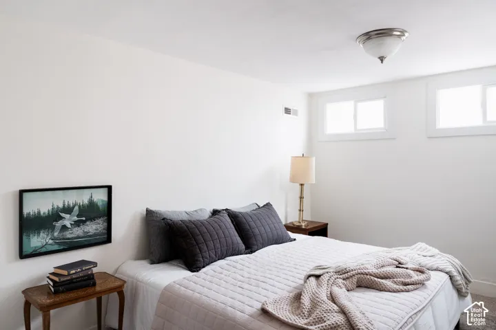 White painted walls, two horizontal windows, and a flush mount ceiling light fixture