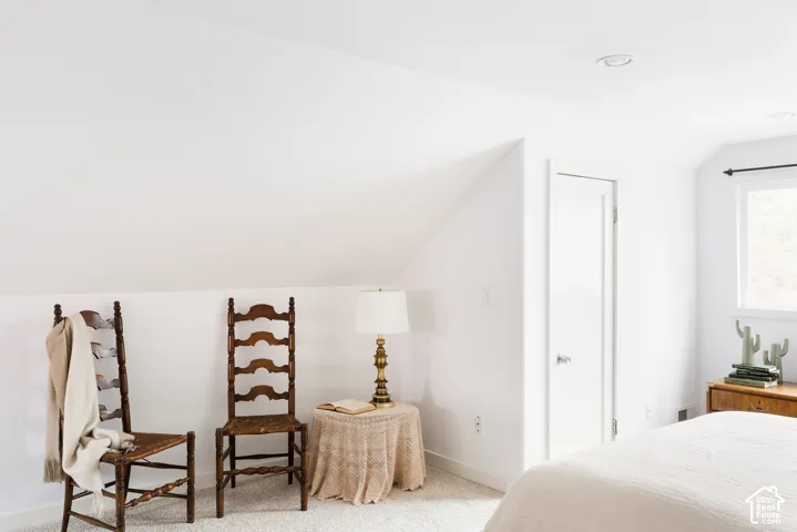 Crisp white walls, sloped ceiling detail, recessed lighting, and a white window frame with black hardware
