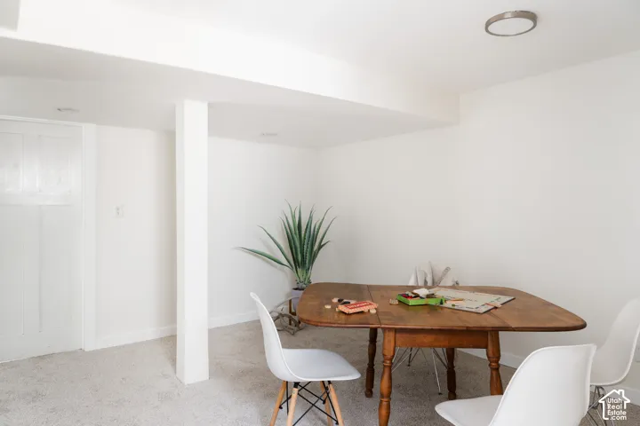 Recessed ceiling lighting, flush-mount ceiling fixture, white paneled door, carpeting, and exposed structural beam