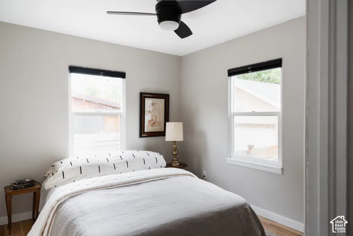 Recessed lighting, wood-finish flooring, two large windows, and a black ceiling fan