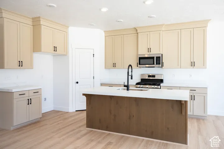 Terrific kitchen with ceiling-height uppers, painted wood cabinets, stained wood island, quartz slab countertops, gas range, microwave, dishwasher and disposal.