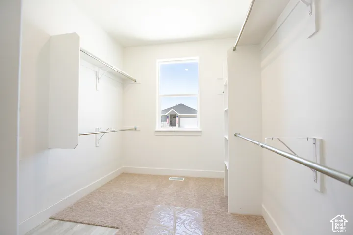 Large closet with stackable washer/dryer hookups as part of primary suite.