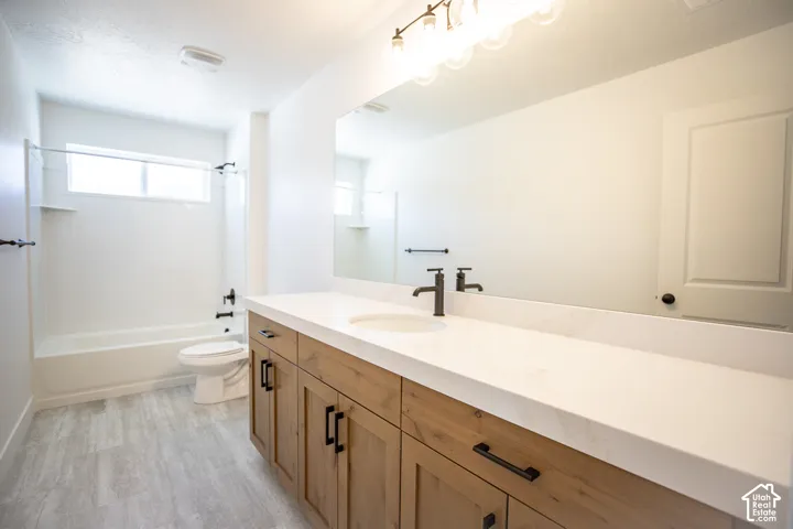 Full secondary bath with extended vanity, stained wood cabinets and quartz slab countertops.