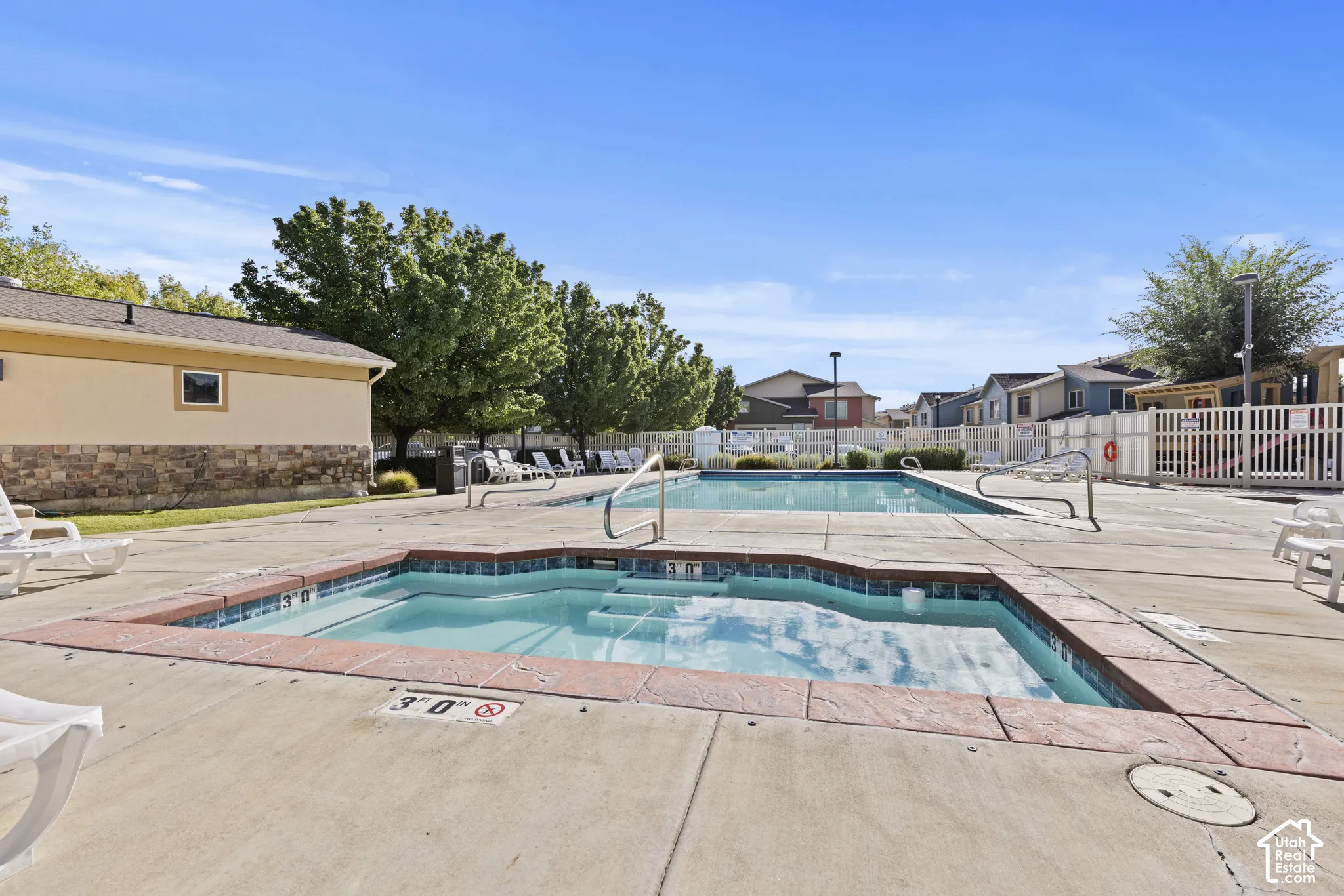 Swimming pool with an integrated spa, surrounded by a concrete deck
