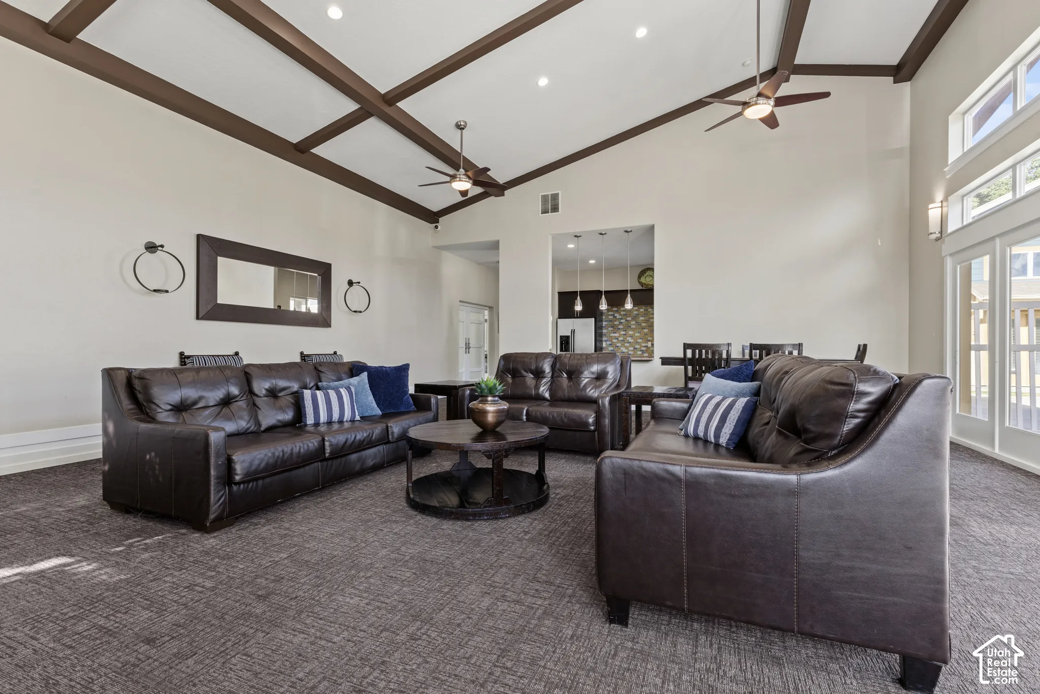 Vaulted ceiling with exposed wood beams, recessed lighting, and dual ceiling fans