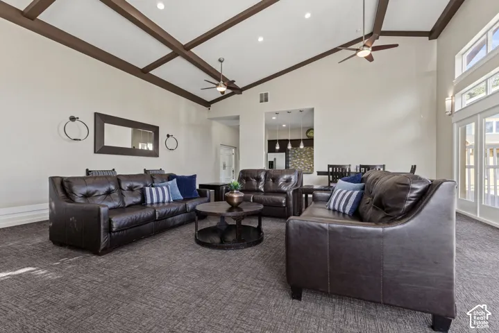 Vaulted ceiling with exposed wood beams, recessed lighting, and dual ceiling fans