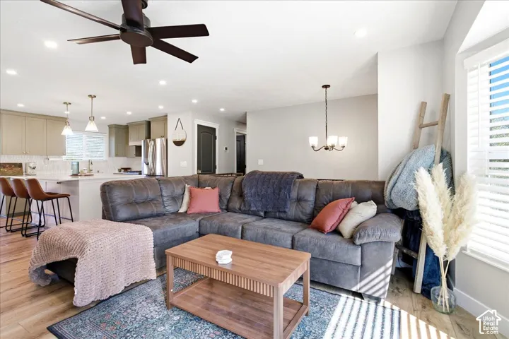 Open-concept living area featuring wood-finish flooring, a ceiling fan, and recessed lighting