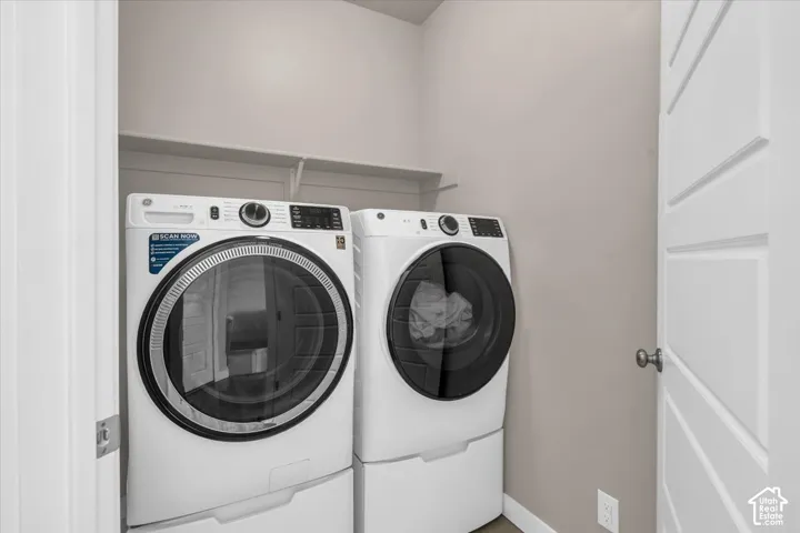 Dedicated laundry area featuring modern appliances and overhead shelving