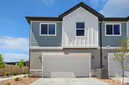 Modern facade featuring horizontal and vertical siding, a two-car garage, and stone-accented foundation