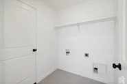 Laundry area featuring a built-in shelf, appliance hookups, and a paneled door with a black knob