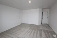 Neutral-toned carpeted flooring, recessed lighting, and white interior doors with dark hardware