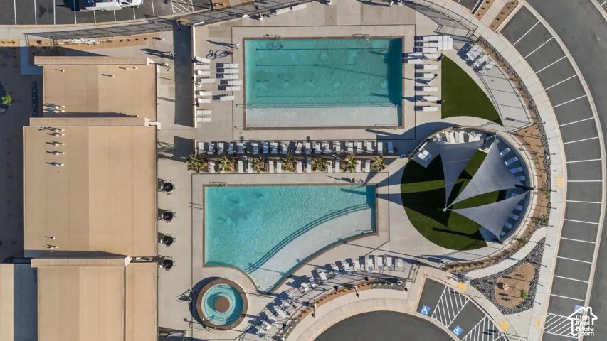 Two distinct swimming pools, a circular spa, extensive paved pool decking, and a shaded artificial turf lounge area