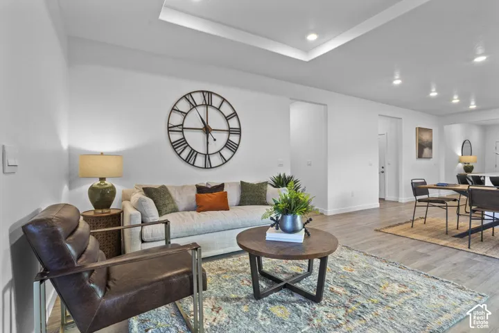 Recessed lighting, tray ceiling, and wood-finish flooring