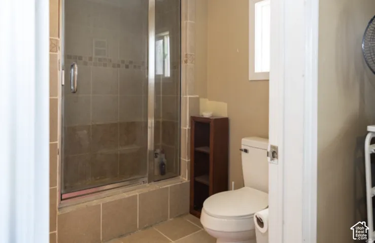 Glass-enclosed shower with tile surround and decorative tile accent band
