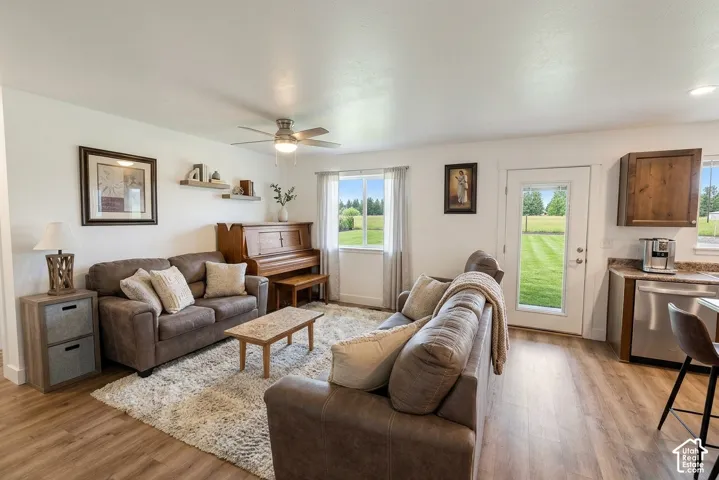 Recessed lighting, wood-finish flooring, ceiling fan, white walls, and a glass-paneled door