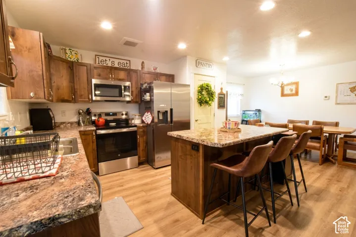 Kitchen featuring wood-finish flooring, recessed lighting, and a kitchen island with seating