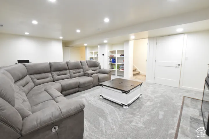 Recessed lighting, light-colored walls, built-in shelving, white interior doors, and gray carpeting