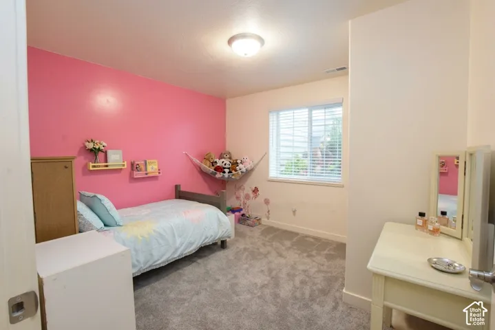 Carpeted room featuring a single window with blinds and built-in wall shelving