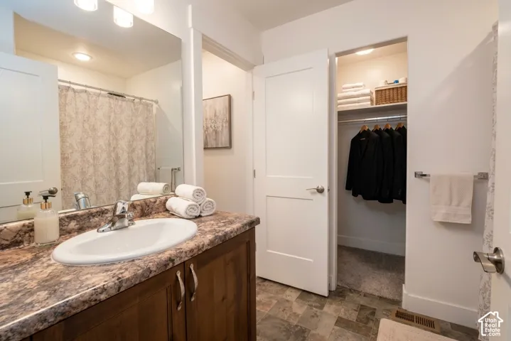 Bathroom vanity with an integrated sink, wood-finish cabinetry, and a patterned countertop