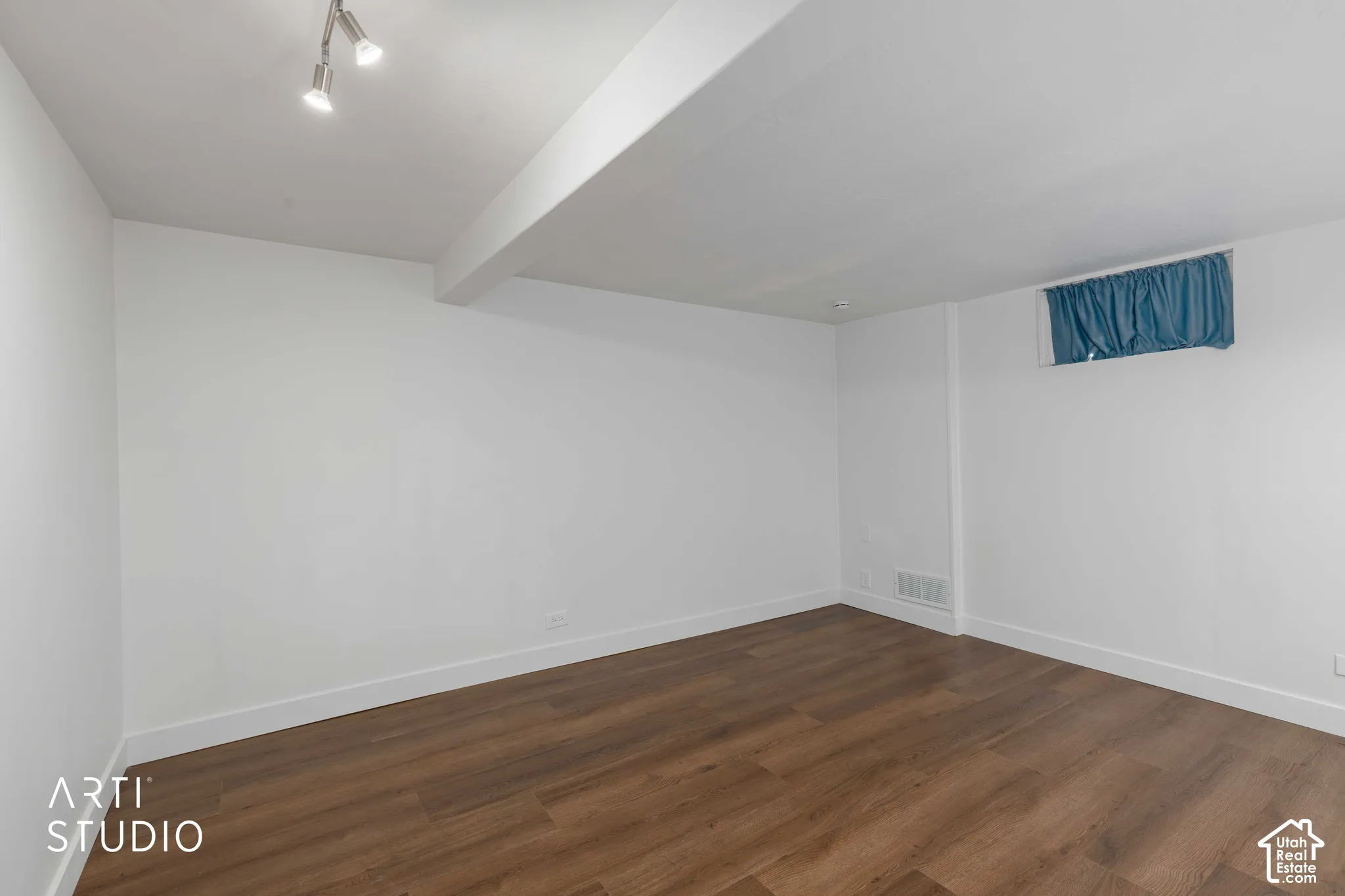Wood-finish flooring, white walls, white trim, recessed lighting, and a single window