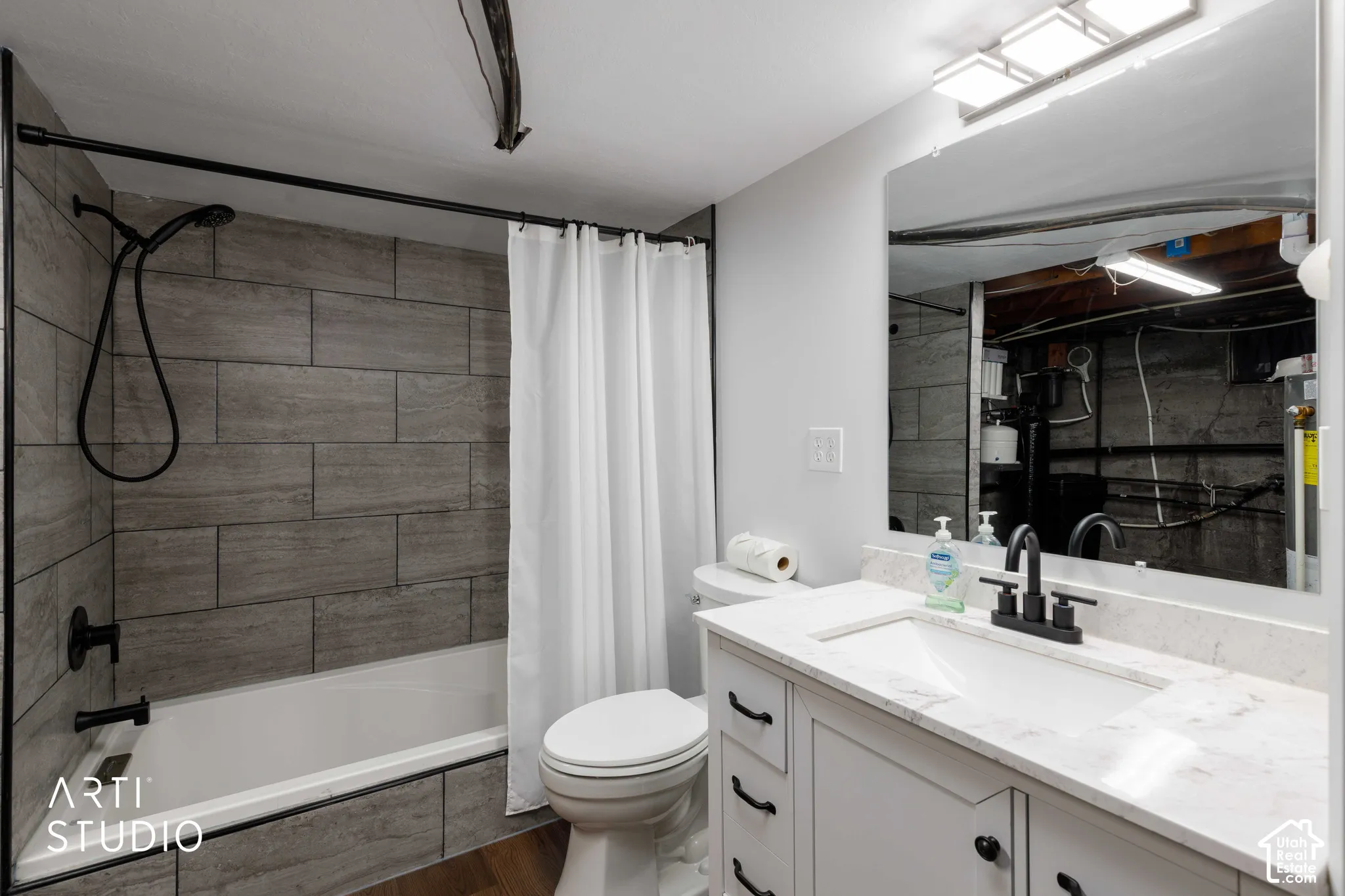 White vanity with a quartz countertop, integrated sink, and matte black faucet