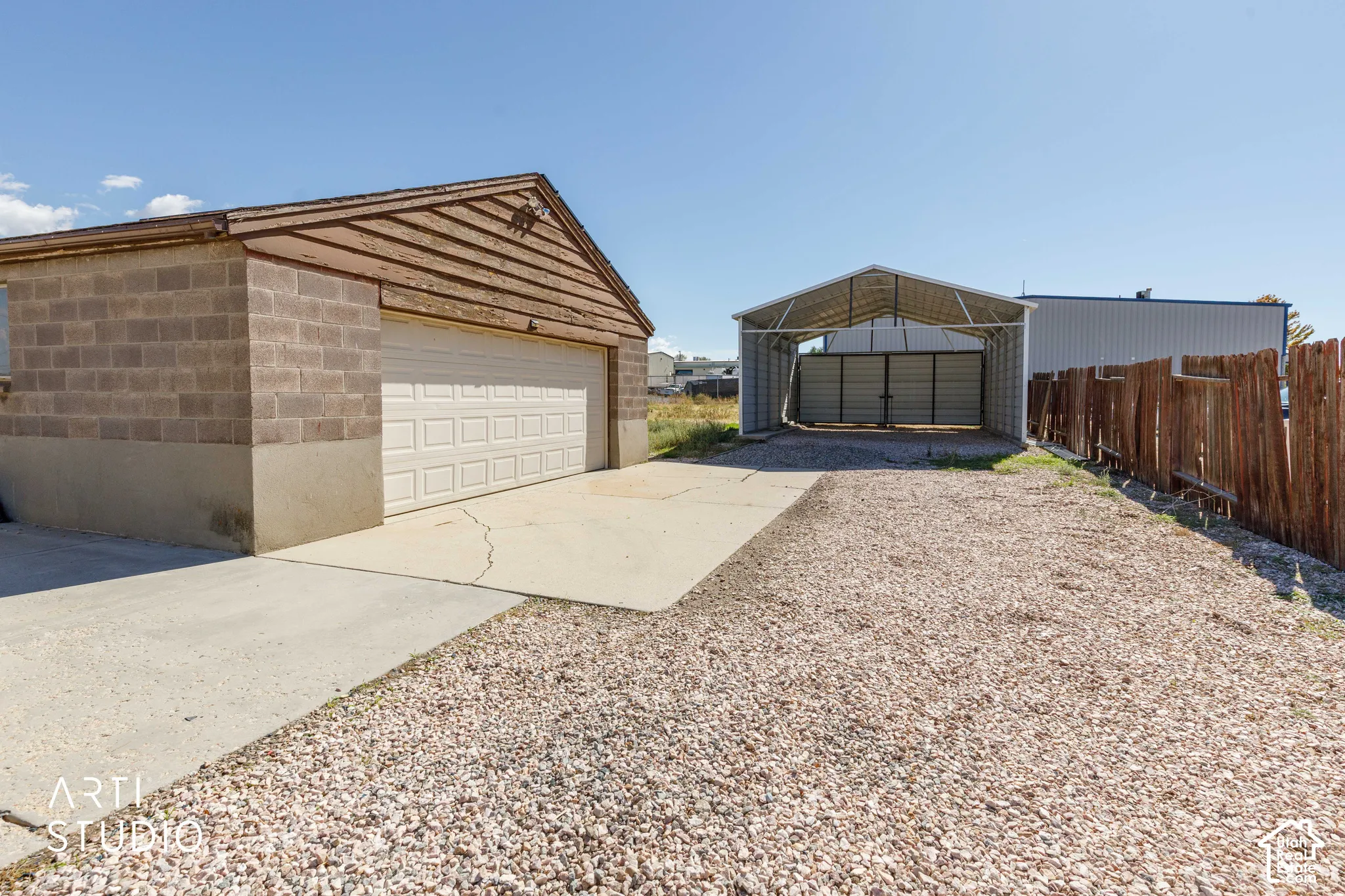 Detached garage with a paneled door, cinder block construction, and an exposed wood gable