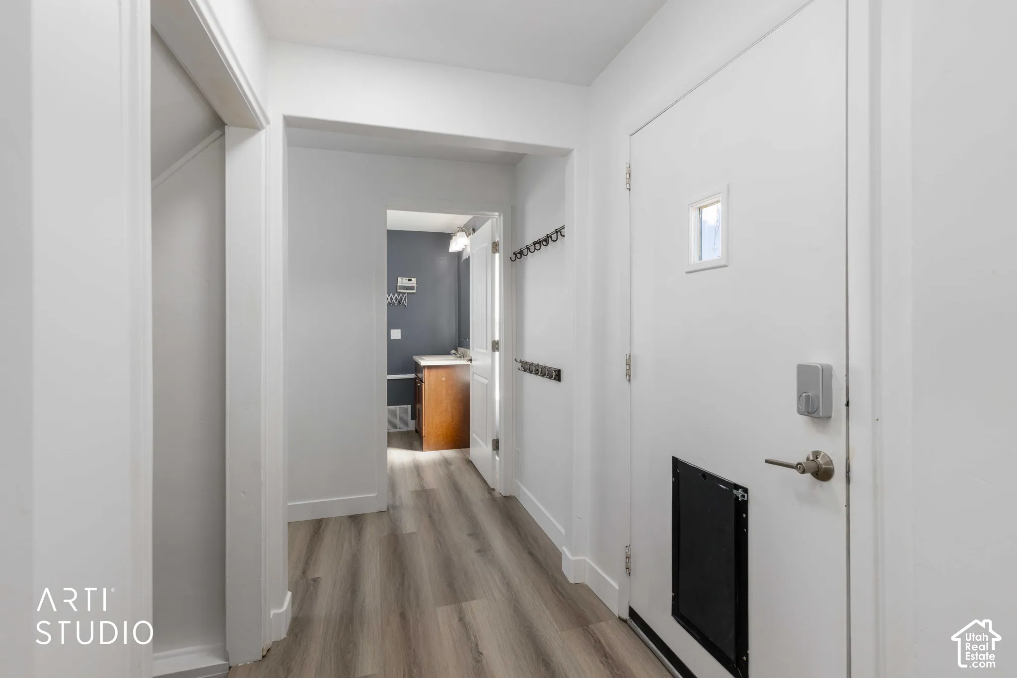 Wood-finish flooring with white baseboards and trim